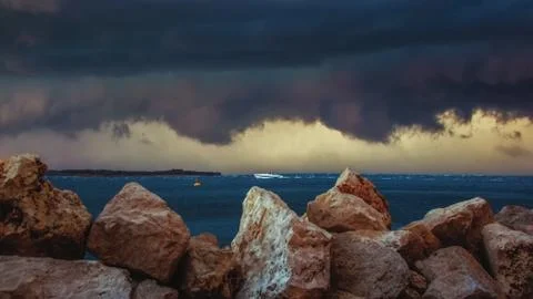 Dark big clouds and thunderstorm passing over the coastline, with heavy rain Stock Photos