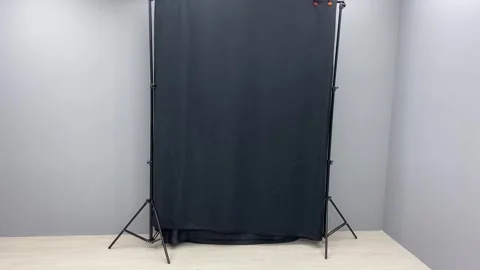 Dark black fabric canvas backdrop near grey wall inside studio. Photoshoot Stock Footage 253533033