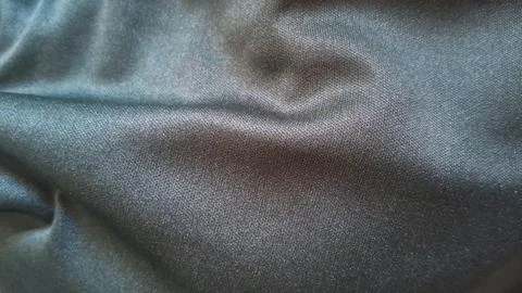 Dark black fabric texture with smooth folds and soft lighting Stock Photos