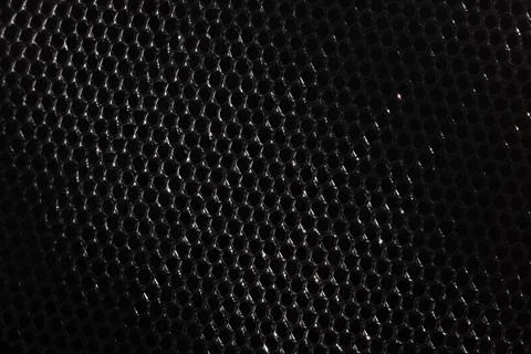 Dark black metallic mesh with subtle silver reflections and repeating hexag.. Stock Photos