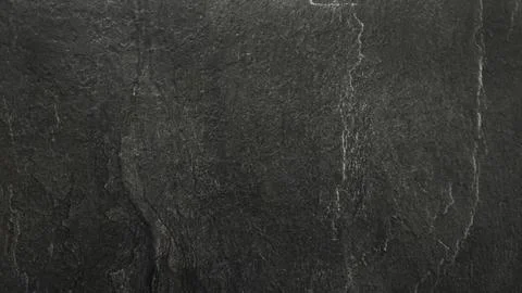 Dark black natural stone surface with subtle cracks, rough texture 写真素材