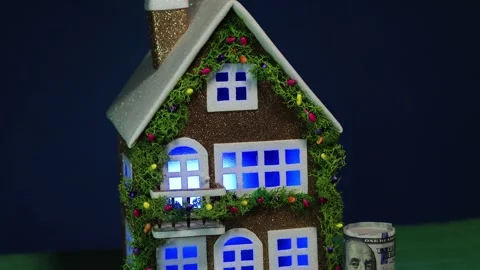 On a dark blue background is a decorated house with dollar bills nearby Stock Footage 340465573