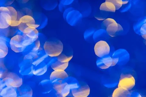 Dark blue background with light effects and white and yellow lens flares Stock Photos