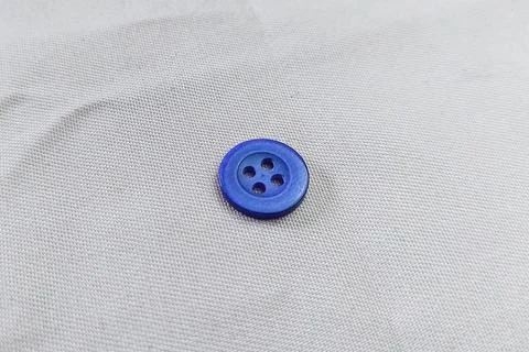 A dark blue button on a fabric texture Stock Photos