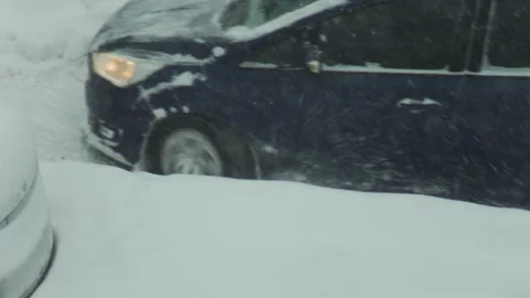 Dark blue car stuck in deep snow, wheels spinning furiously. Vehicle bogged down Stock Footage 326752520