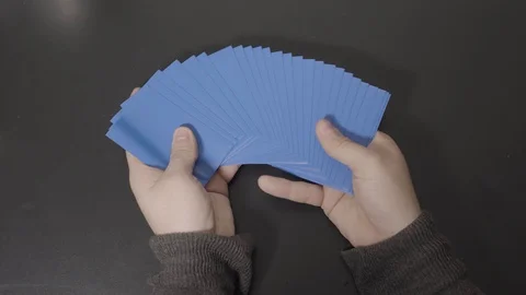 Dark Blue Cards Displayed in Hands then Straightened Stock Footage 100557565