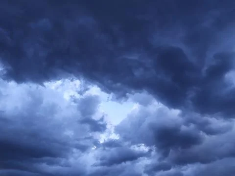 Dark blue clouds gathered in the form of a heart before the rain Stock Photos