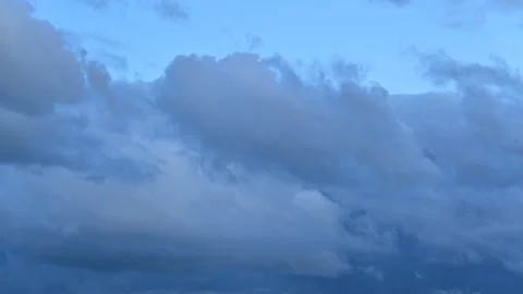 Dark blue clouds swiftly floating across blue sky Stock Footage 260850903
