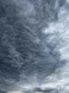 Dark blue cloudy sky with low clouds Stock Photos