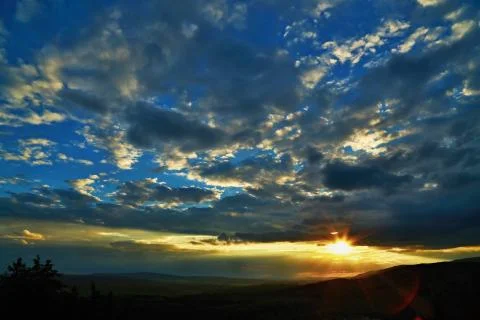 Dark blue cloudy sky with sunset Stock Photos