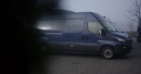 Dark Blue Delivery Van Parked on Paved Lot, Foggy Industrial Morning, Wide Shot Stock Footage 340364655