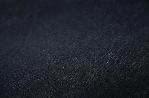 Dark blue denim close-up selective focus. Denim fabric, jeans textured Stock Photos