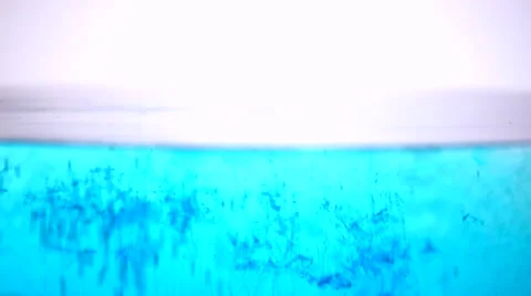 Dark Blue dye being sprinkled into and dissolving in a water bath Stock Footage 50170224