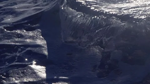 Dark blue ocean wave curling softly under bright shimmering sunlight. Stock Footage 337409729