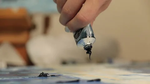 Dark blue paint is extruded onto a canvas from a tube Stock Footage 113786676