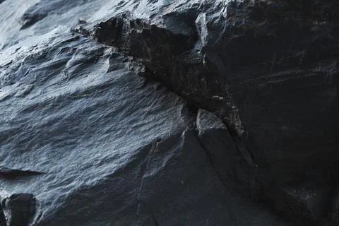 Dark blue sedimentary rock surface with a deep diagonal crack across the te.. Stock Photos