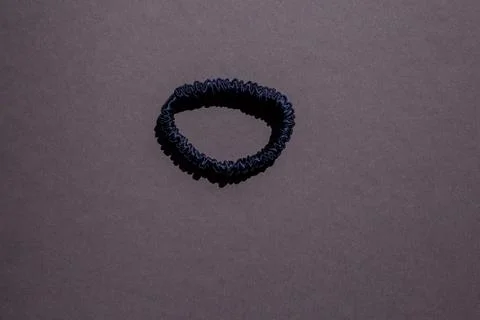 Dark blue silk scrunchie on a dark gray background Stockfoto's