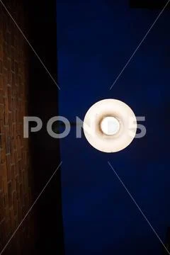 Dark blue sky bright bulb red brick wall simplicity background Stock Photos