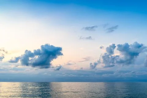 Dark blue sky with low clouds in over calm sea Stock Photos