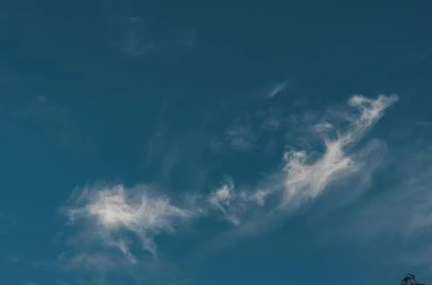 Dark blue sky with small cloud air, cloud evaporates under influence sun Stock Photos