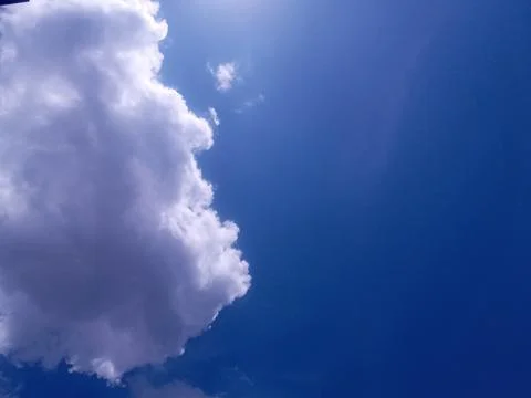 Dark blue sky with white clouds in sunny day. Stock Photos