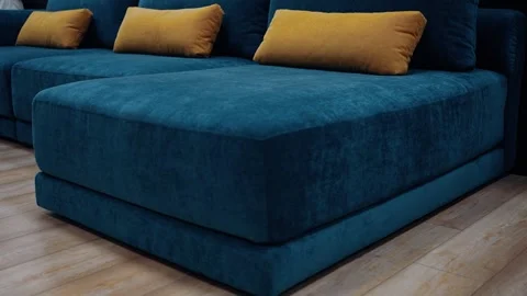 Dark blue smooth sofa model with long yellow cushions. 4k video Stock Footage 231507913
