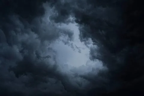 Dark blue storm clouds before rain. Bad weather, darkness, death. Stock Photos