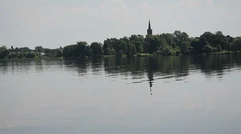Dark blue surface of water in distance a beautiful church tower Stock Footage 38813433