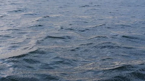 Dark blue water surface of a lake, sea, ocean with waves, ripples and sun glare Stock Footage 243708499
