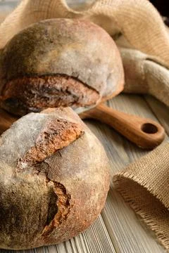 Dark bread close-up with burlap and cutting board. Stock Photos