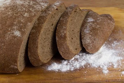 Dark bread cut on a board with flour Foto stock