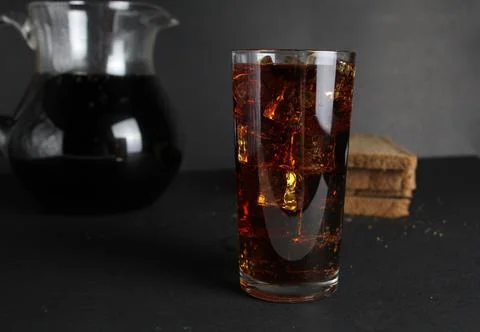 Dark bread kvass poured into a glass with solder and stands in a jug on a gra Stock Photos