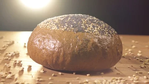 Dark bread sprinkled with grains is spinning on the table Stock Footage 76507470
