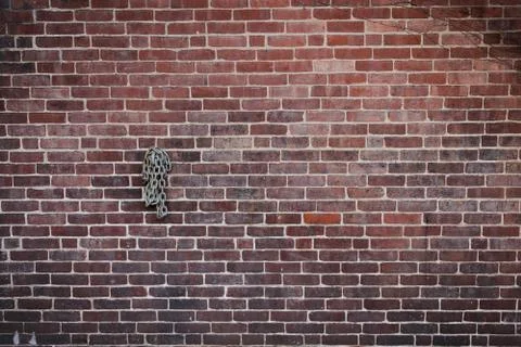 Dark Brick Wall with Rolled Up Chain Hanging 写真素材