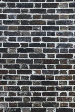 Dark brick wall texture forming a random pattern Stock Photos