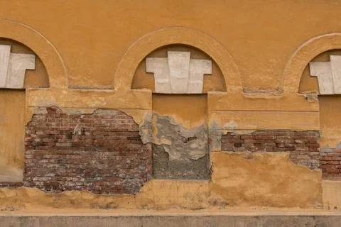 The dark brick wall with three rounded closed windows. Stock Photos