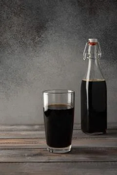 Dark brown bottle with a bugle plug of homemade kvass and glass. Rustic style Stock Photos