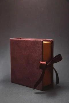 Dark brown box for a flash drive with a cover from a suede, tied to satin rib Stock Photos