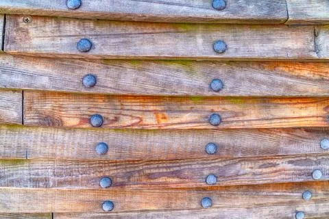 Dark brown horizontal planks pattern and row of iron rivets Stock Photos