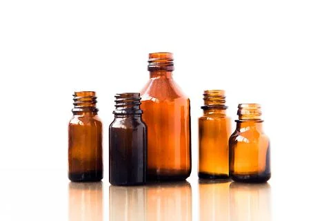 Dark brown phials on white background. Small empty bottles. Stock Photos