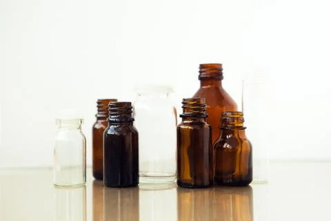 Dark brown phials on white background. Small empty bottles. Stock Photos