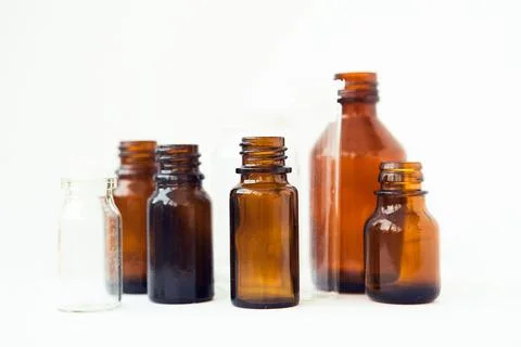 Dark brown phials on white background. Small empty bottles. Stock Photos