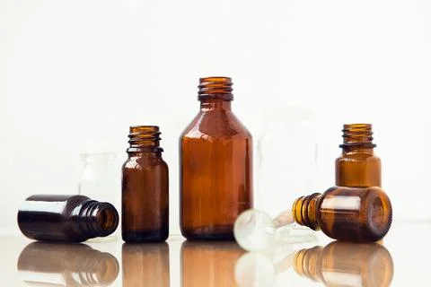 Dark brown phials on white background. Small empty bottles. Foto stock