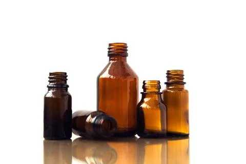 Dark brown phials on white background. Small empty bottles. Stock Photos