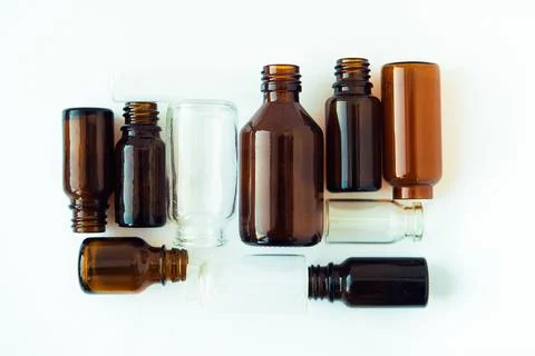 Dark brown phials on white background. Small empty bottles. Stock Photos