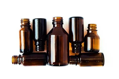 Dark brown phials on white background. Small empty bottles. Stock Photos