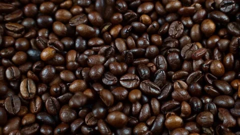 Dark brown roasted coffee beans falling down on rotating background close up Stock Footage 232464978