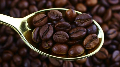 Dark brown roasted coffee beans in spoon with circle rotation top view 스톡 동영상 238481428