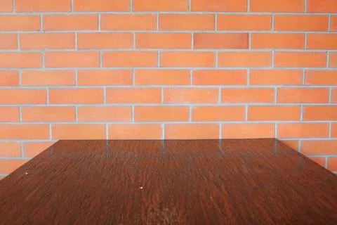 Dark brown table and brick wall. Stock Photos