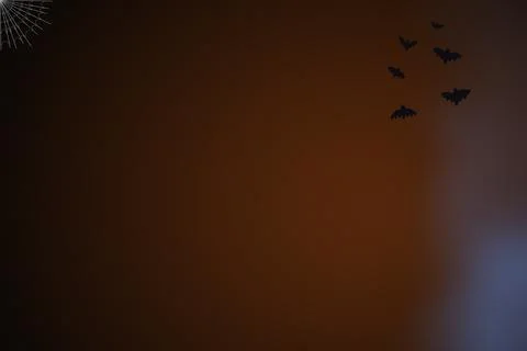Dark brown textured background decorated with flying bat silhouettes and a .. Stock Photos